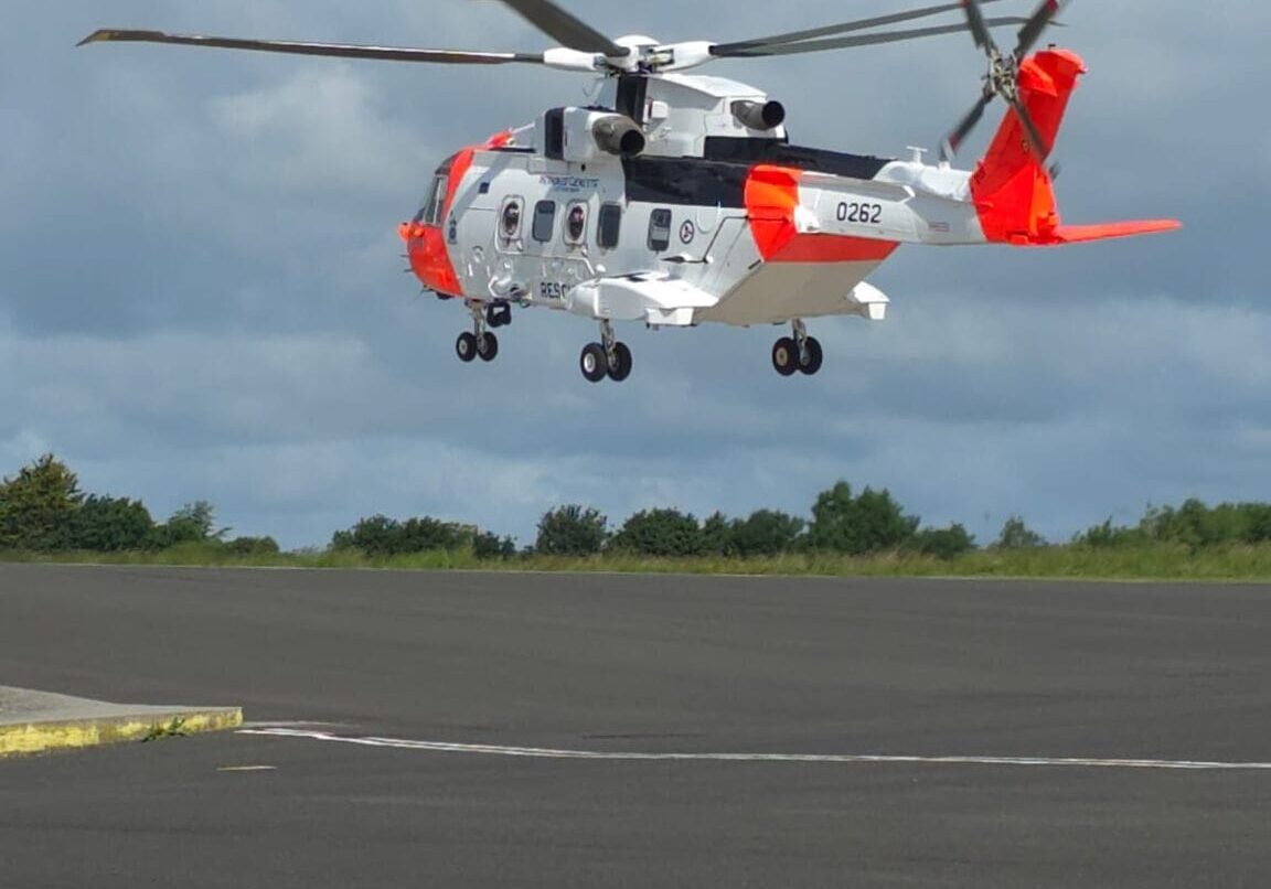 NOR01 drar fra Yeovil_2 Oransjt og hvitt helikopter tar av fra bakken.